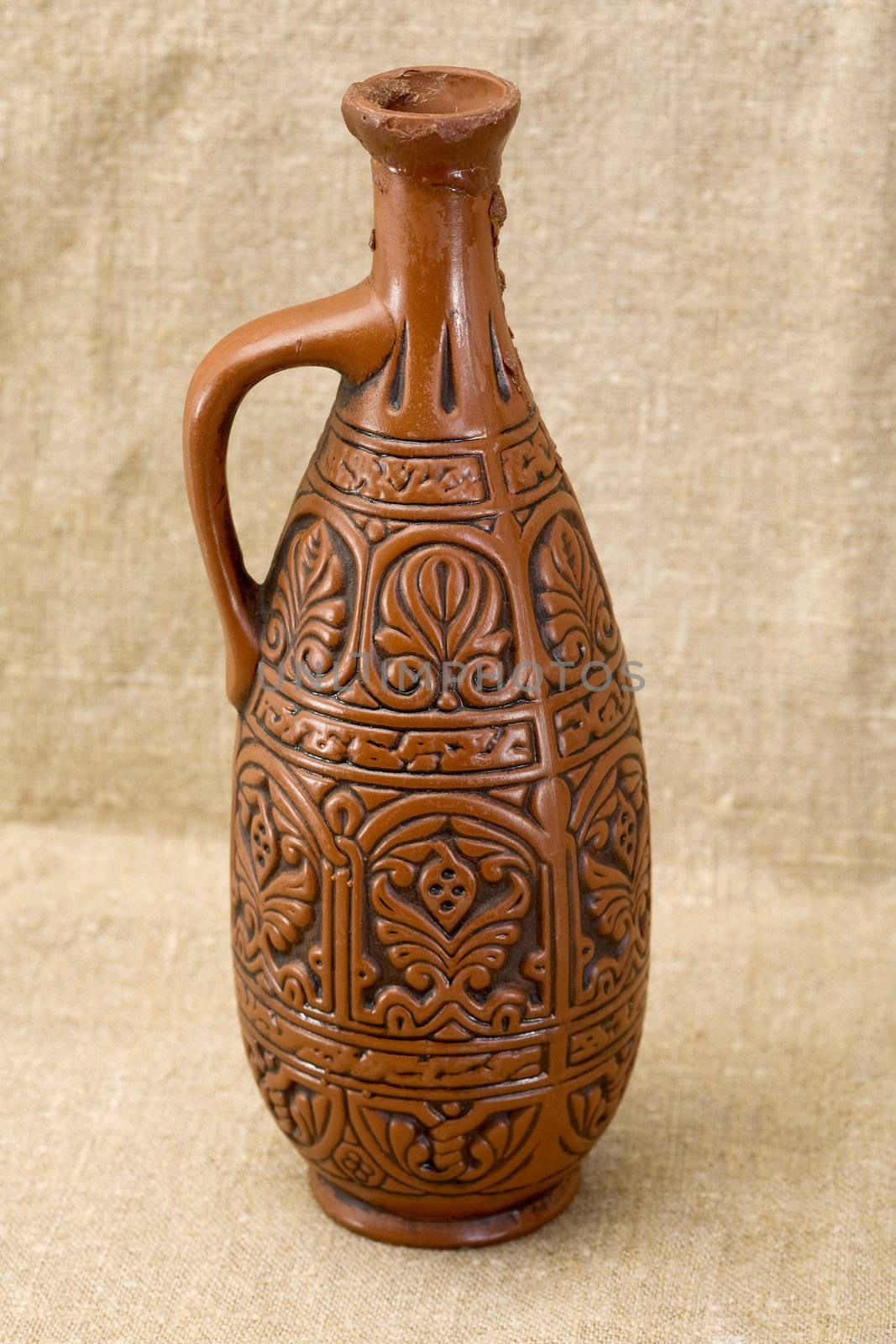 Ancient clay large bottle on fabric background
