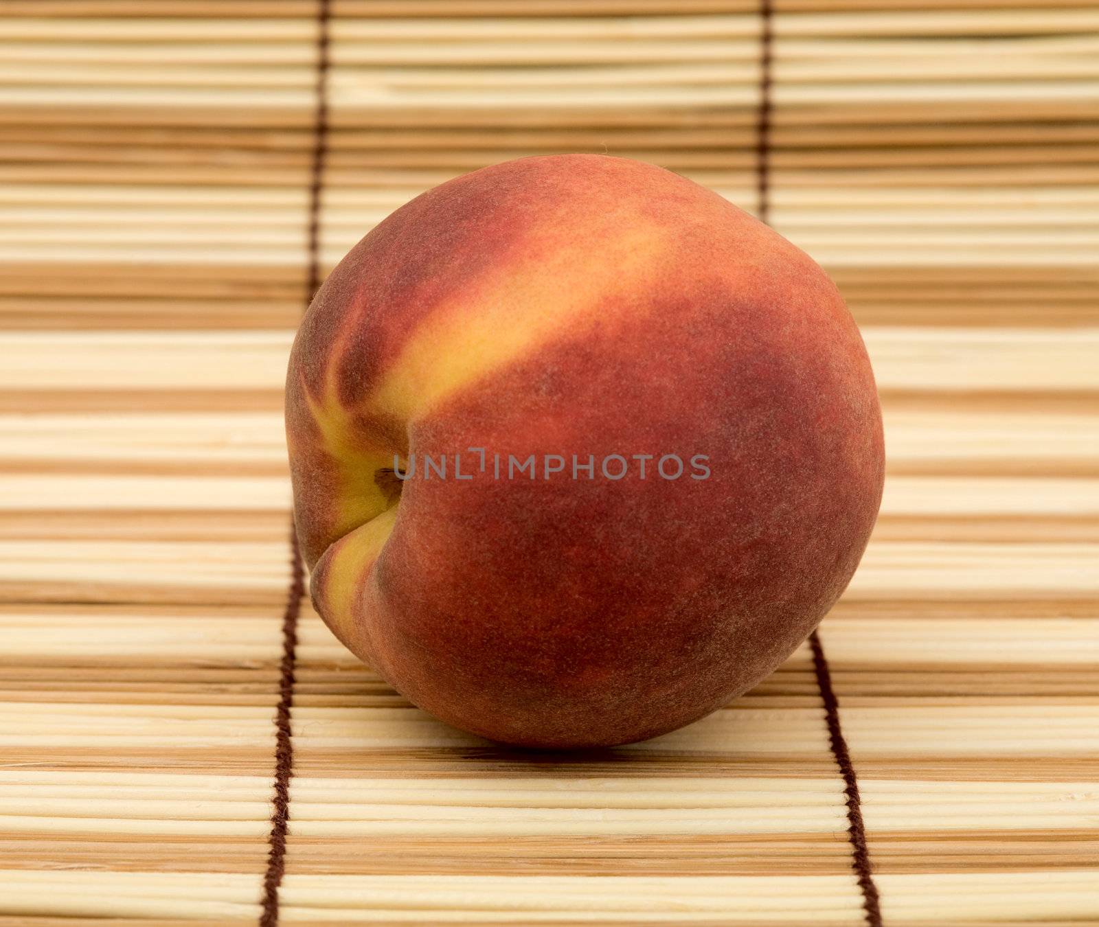 Ripe peach on the wooden mat background