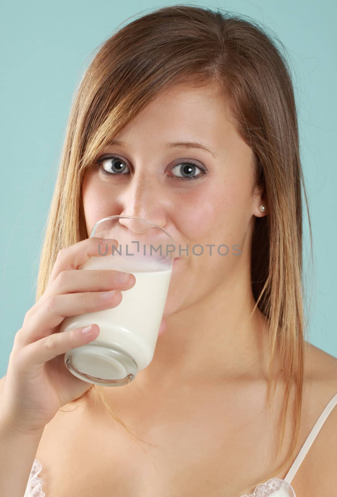 young caucasian woman drinkin a glass of fresh milk