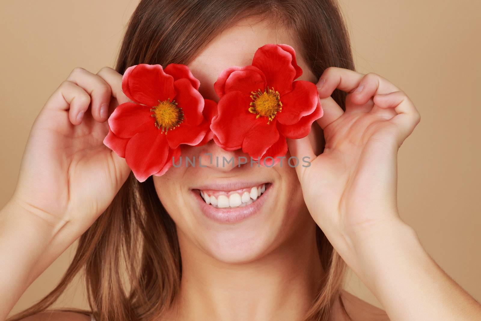 woman hiding her eyes behind red fake flower