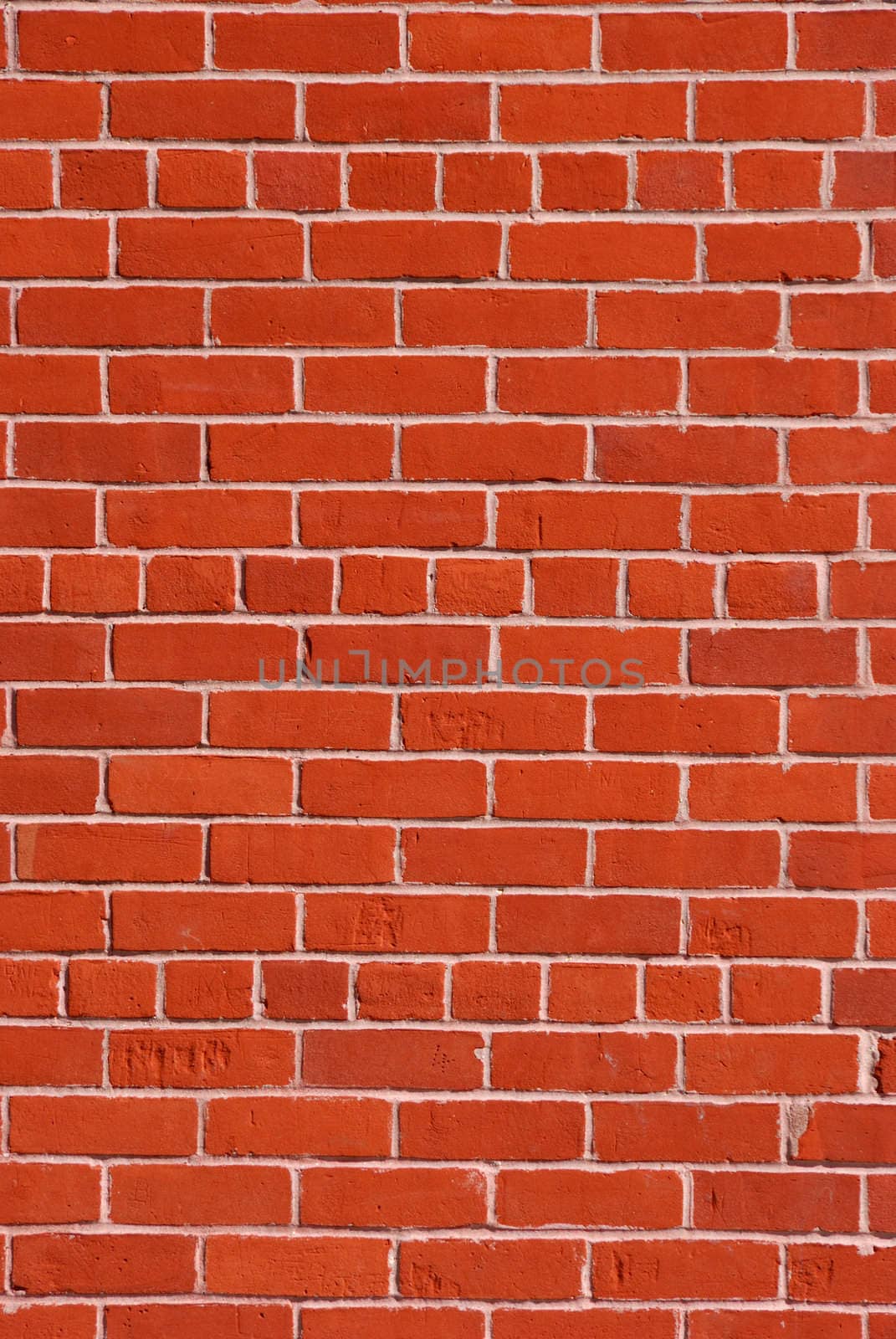 Red brick wall with light cement in between.