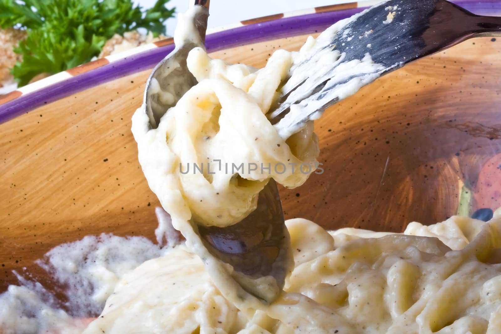 close up of alfredo noodles with a spoon and fork