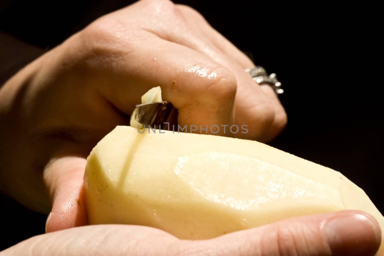 a women peeling a potato close up of the womens hands