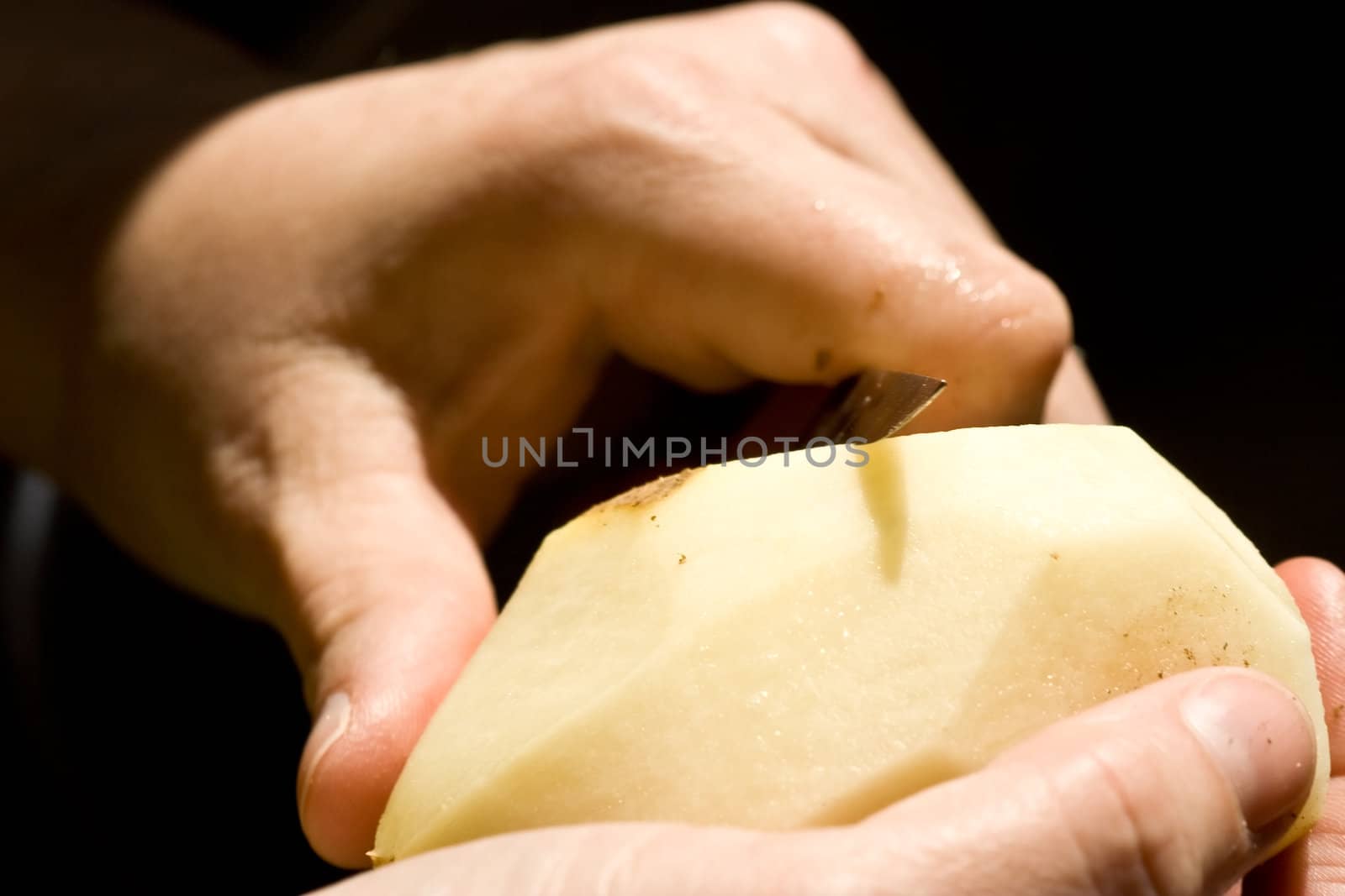 a women peeling a potato close up of the womens hands