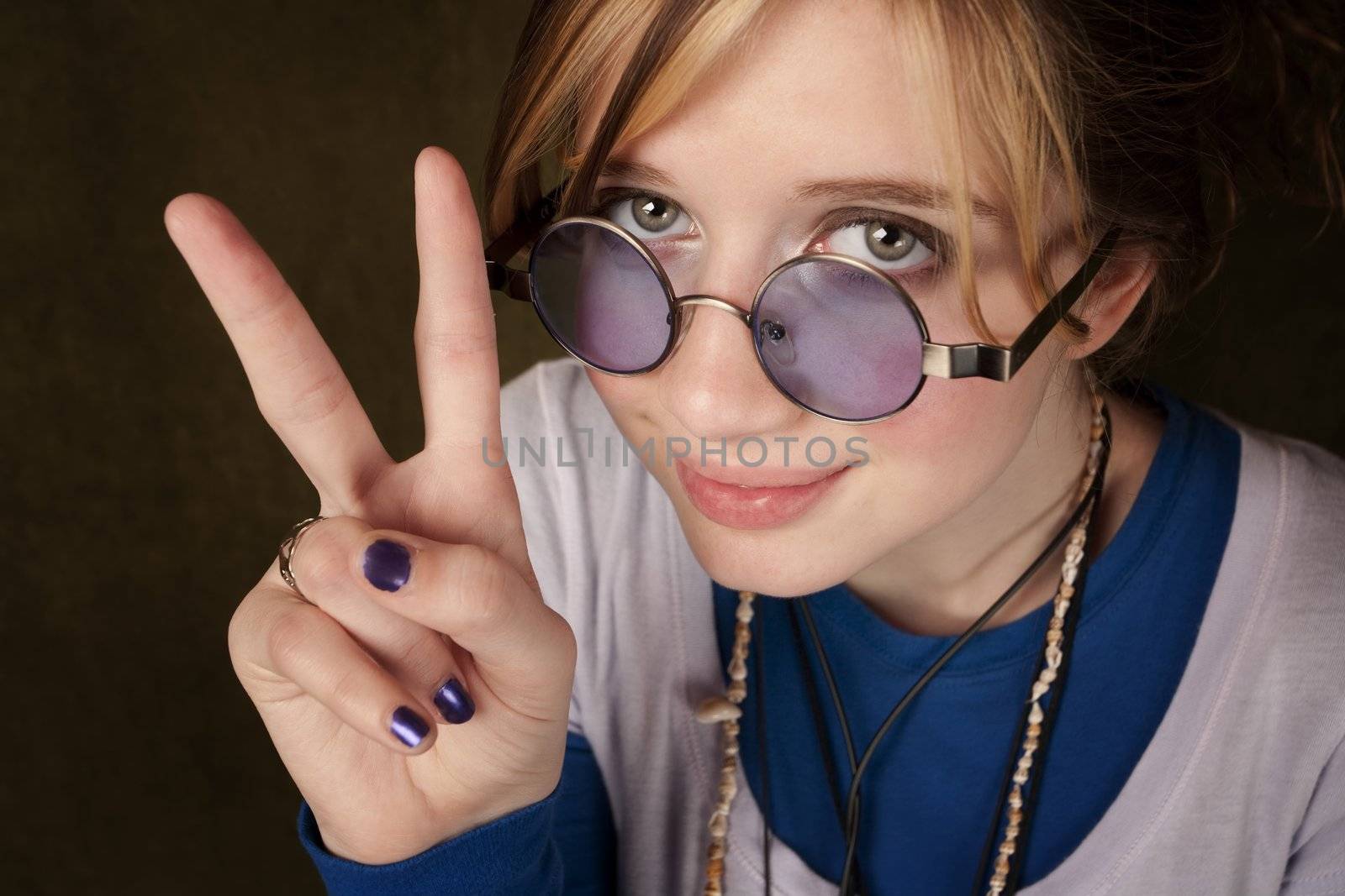 Pretty teen girl making a peace sign with her hand