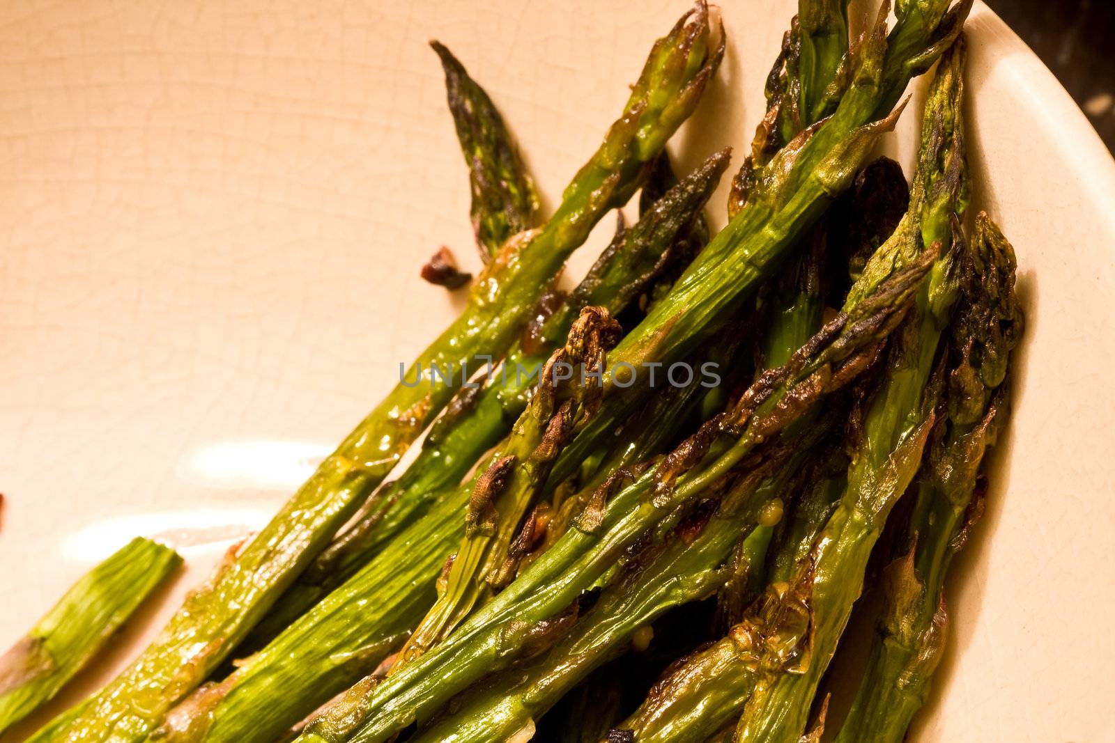 hot asparagus baked in an oven coated with oil salt and pepper