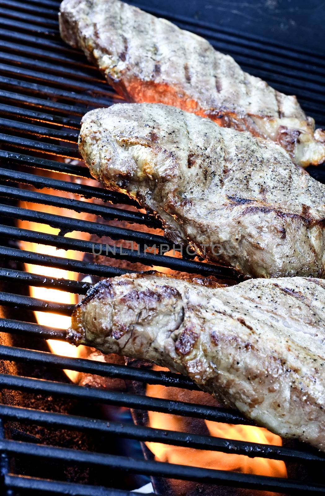 Grilling steaks on the grill nice cuts of meat close up shot shallow DOF