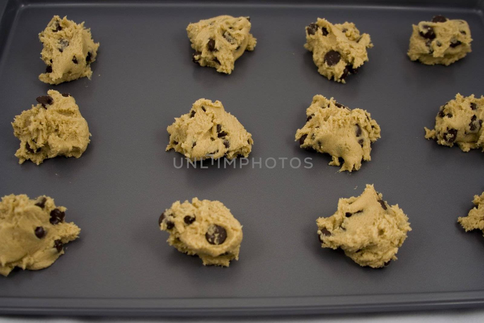 A cookie sheet of chocolate chip cookies ready for the over.