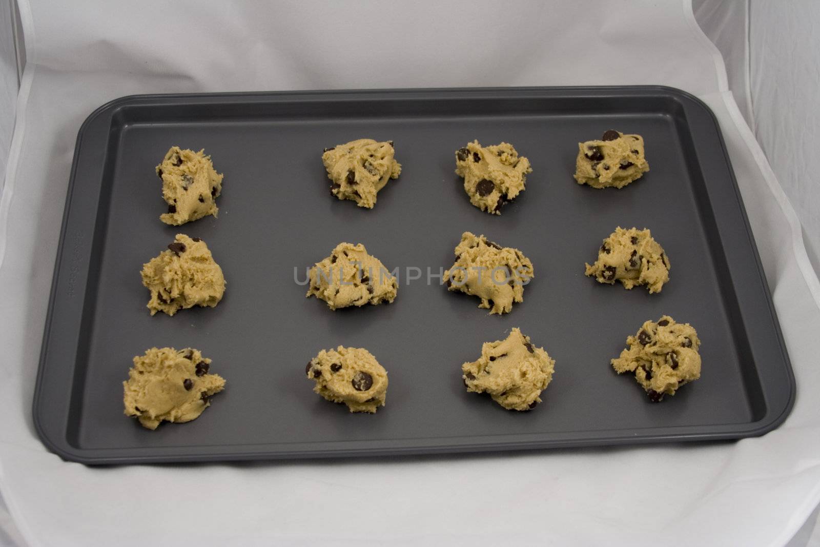 A cookie sheet of chocolate chip cookies ready for the over.