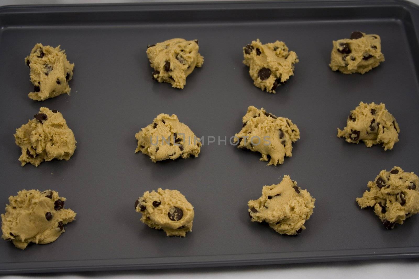 A cookie sheet of chocolate chip cookies ready for the over.