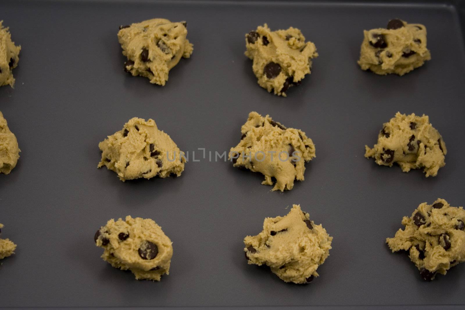 A cookie sheet of chocolate chip cookies ready for the over.