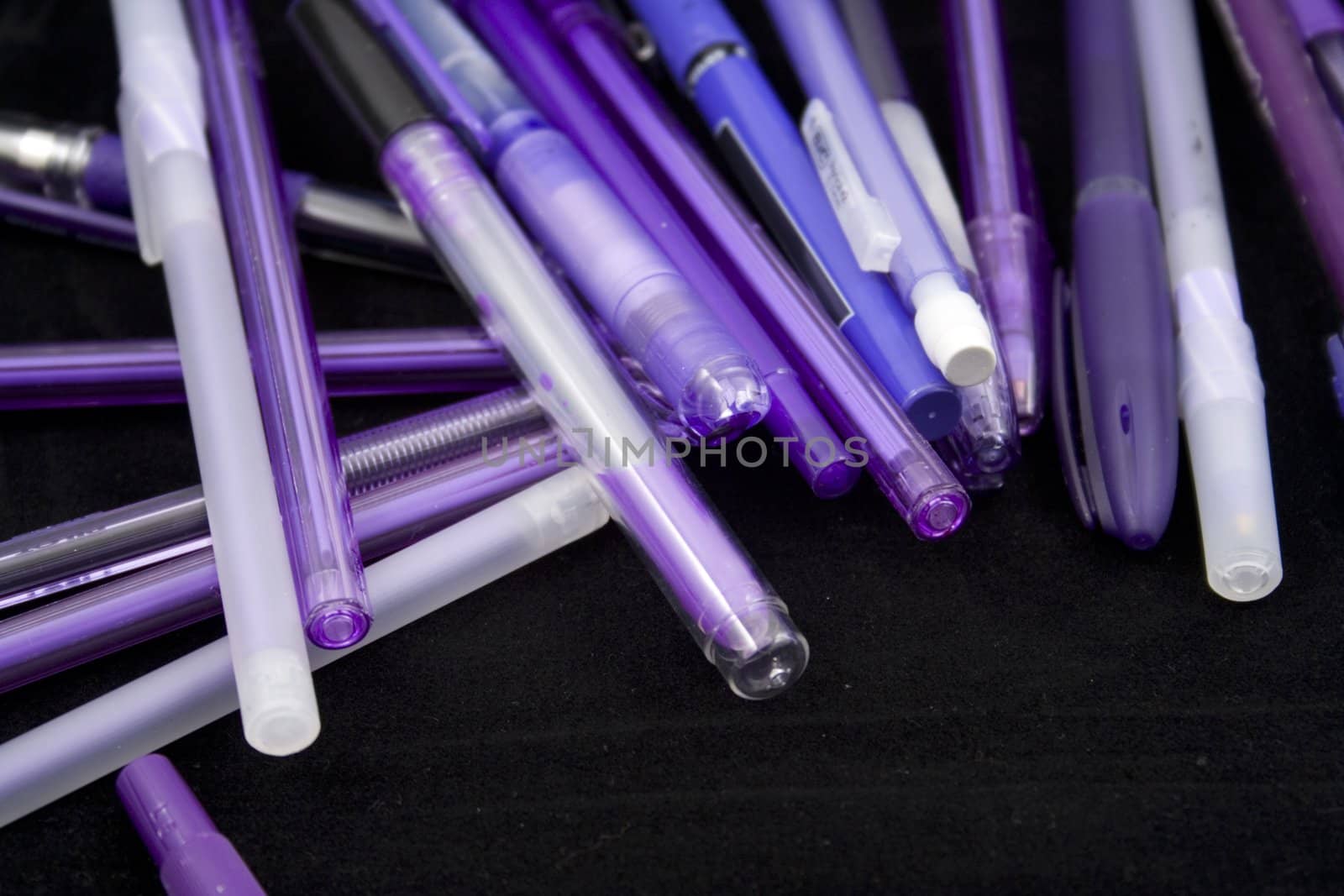 Pile of purple pens just waiting for someone to pick one up and start writing