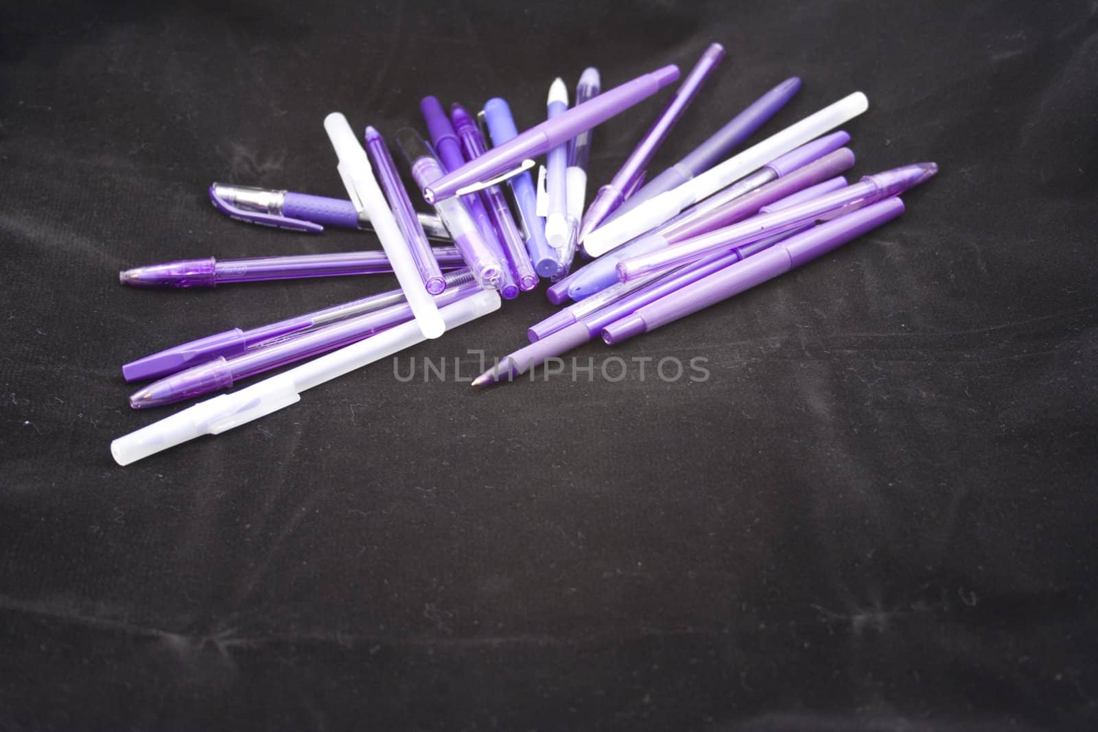 Pile of purple pens just waiting for someone to pick one up and start writing