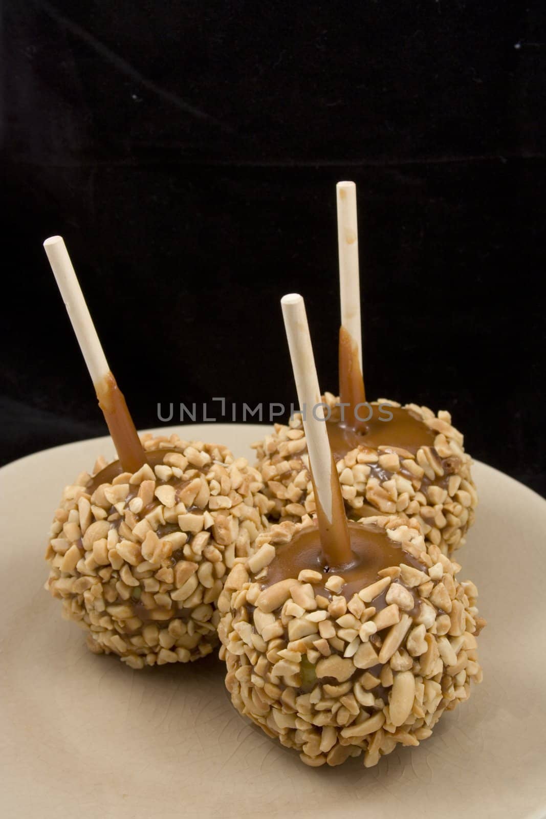 Carmel apples with nuts on a plate just in time for the holidays