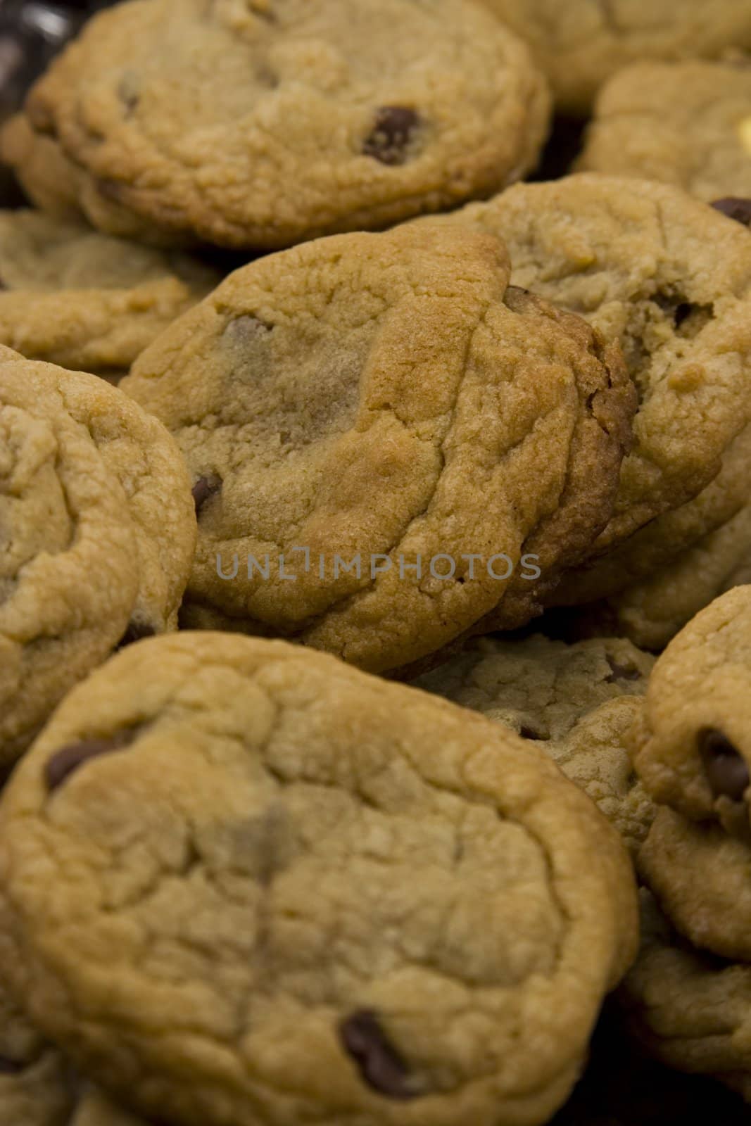 a close up of a mountain of chocolate chip cookies hot to go