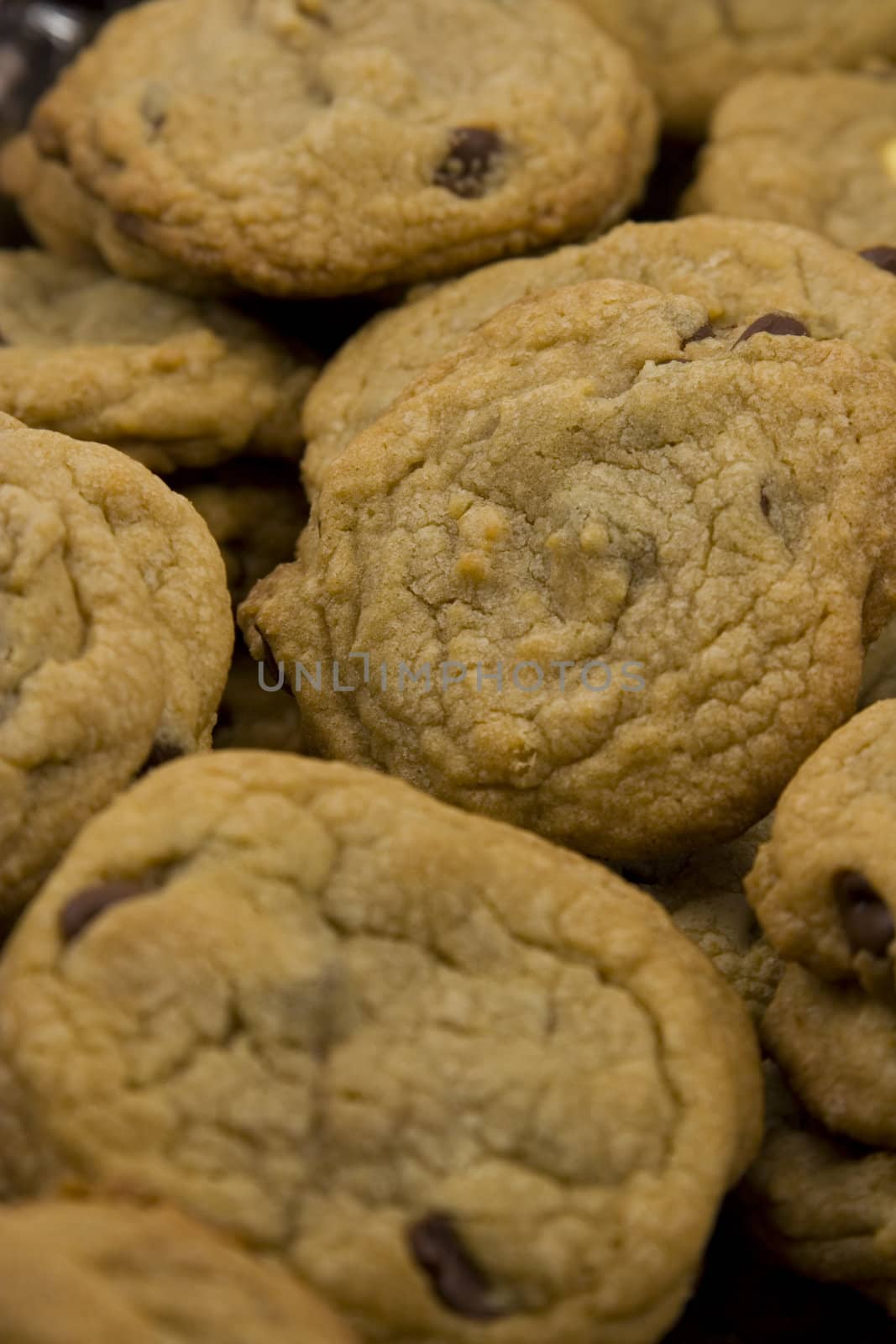 a close up of a mountain of chocolate chip cookies hot to go