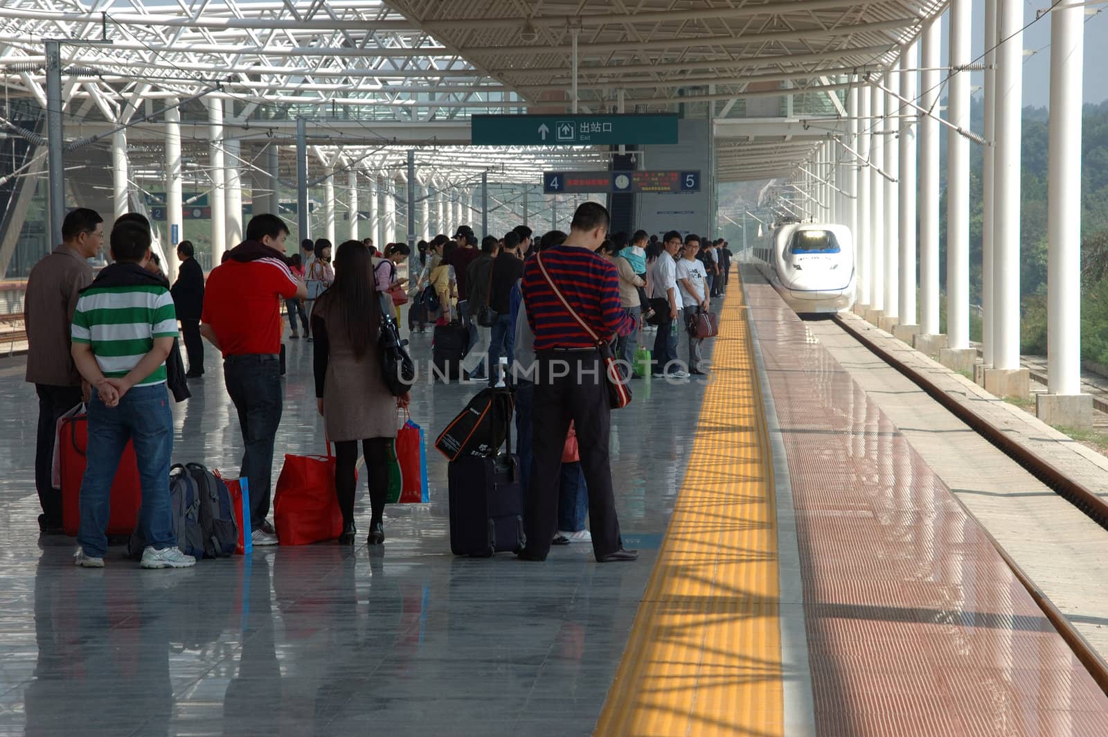 YUEYANG - HUNAN, CHINA - OCTOBER 3: China invests in fast and modern railway, trains with speed over 340 km/h. Passengers wait for train to Guangzhou on October 3, 2010 in YueYang station.