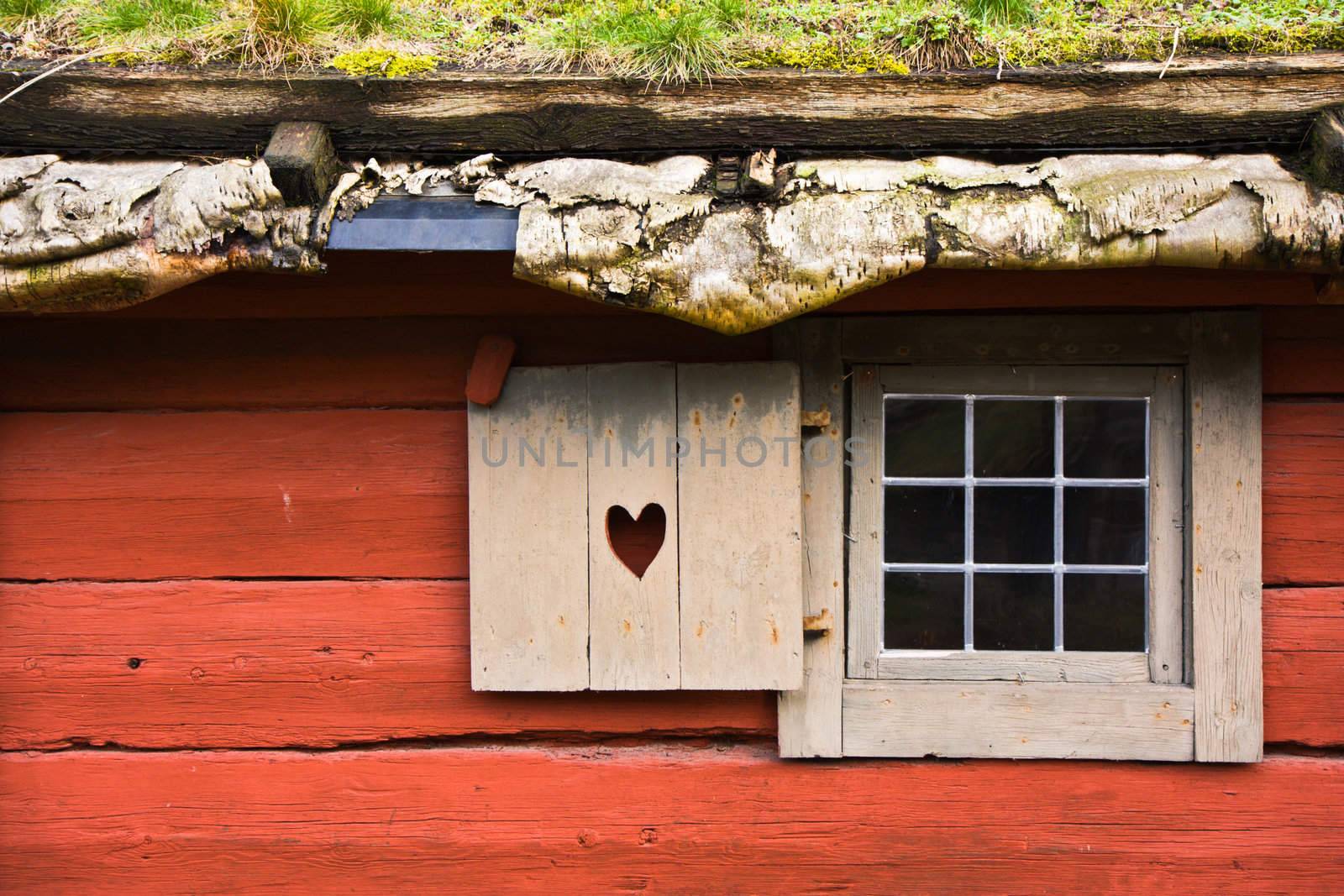 Window of a red wooden cottage