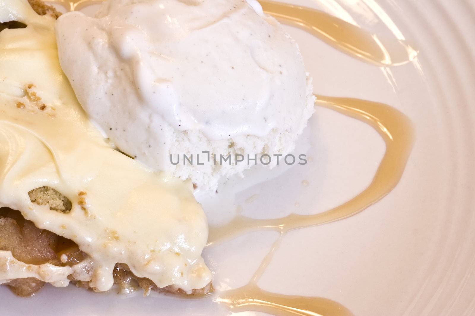 slice of apple pie frosted with vanilla ice cream on white plate