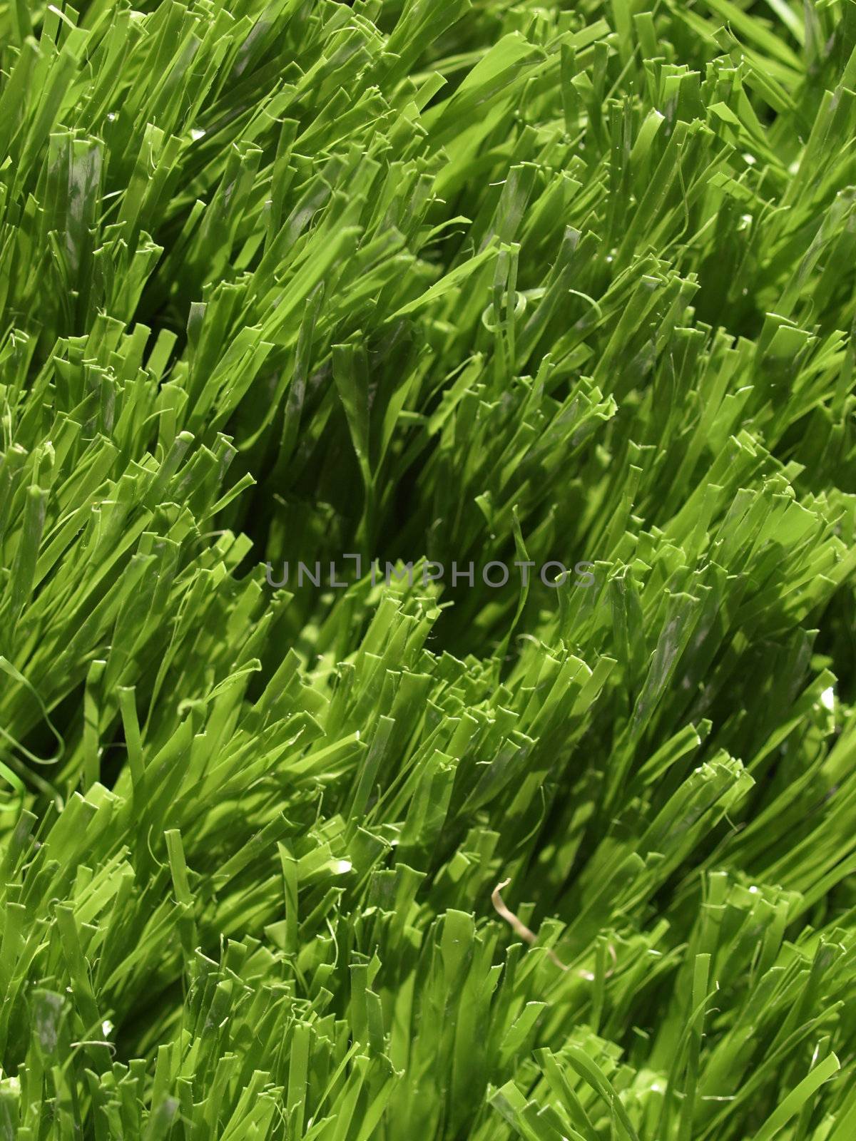 Detail of green grass artificial lawn meadow, useful as a background