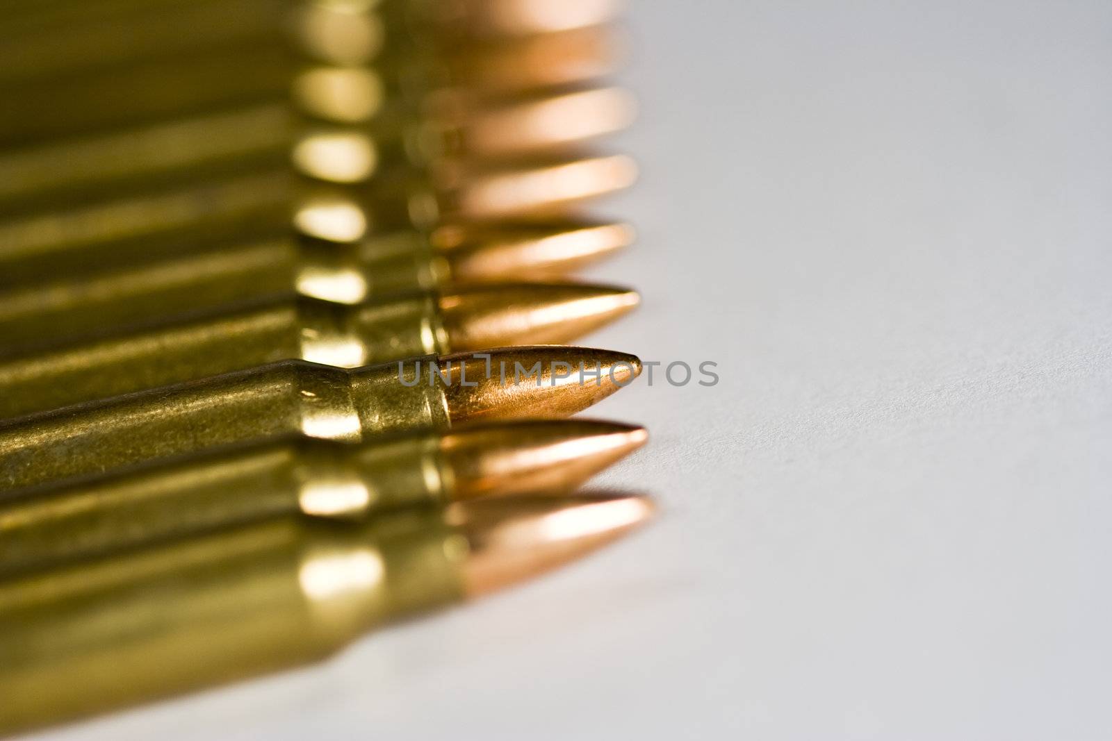 Row of rifle rounds on white sharp focus going to a nice blur