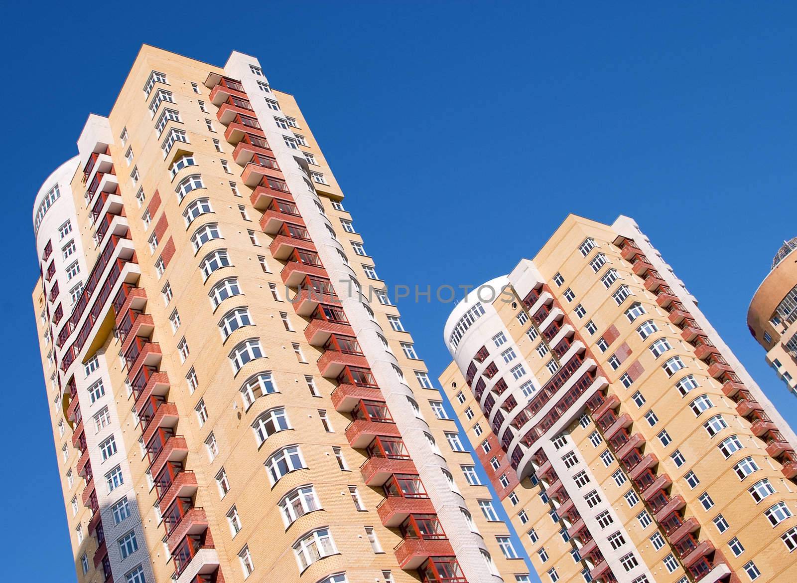 Modern tall residential building on a background of blue sky.