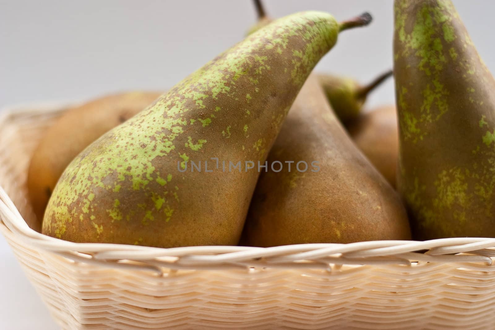 Pears in the basket on a gray background.
