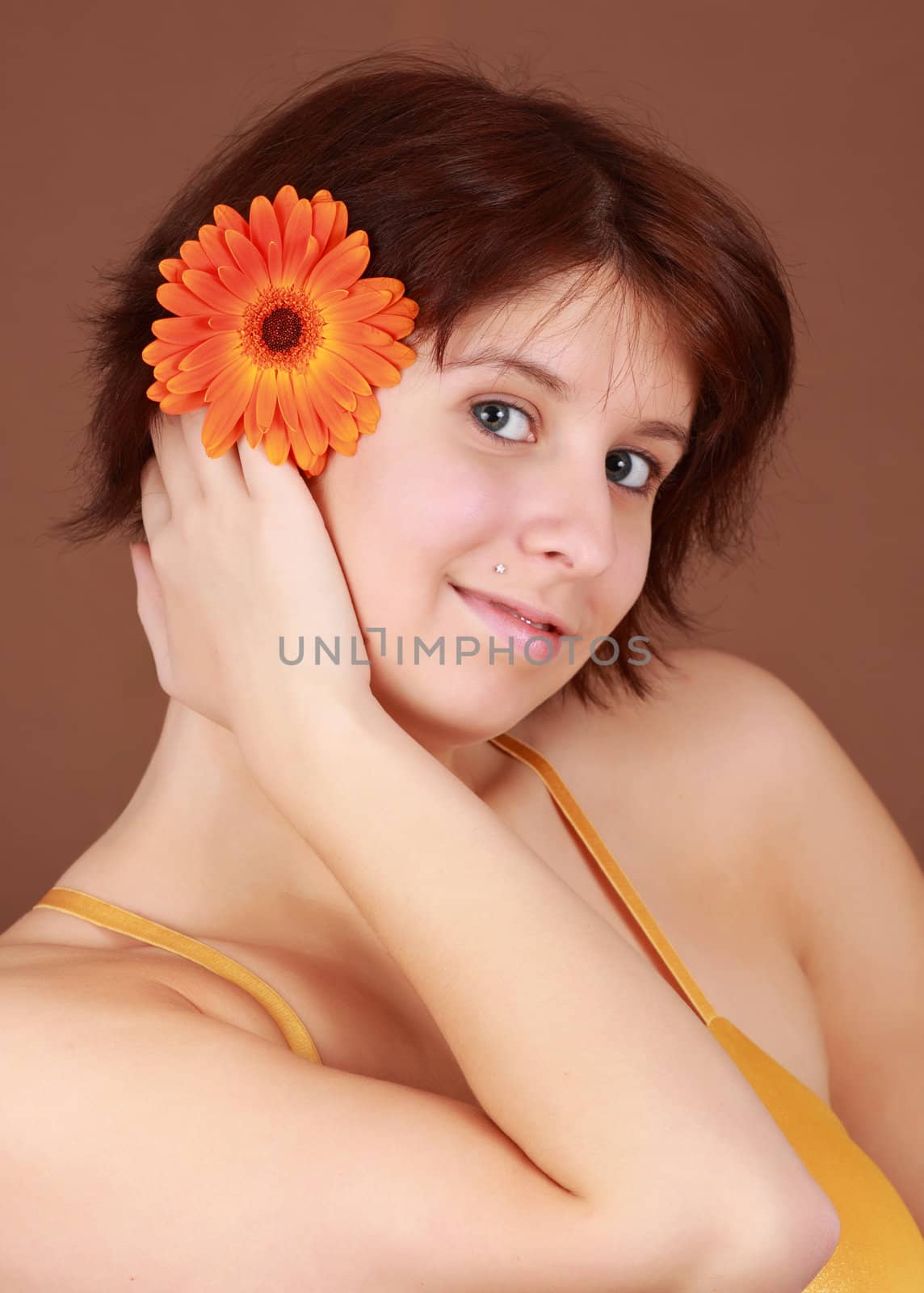 girl with an orange gerber flower in hair