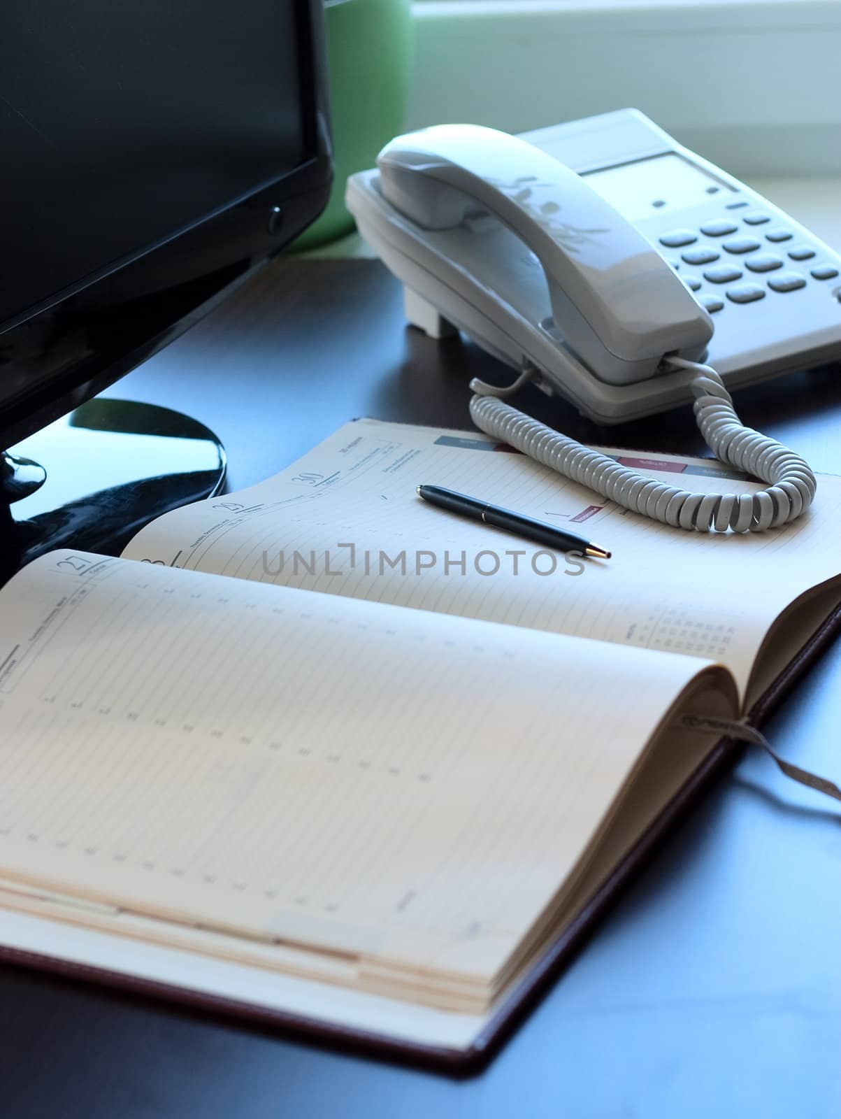 Personal workplace: table, monitor, business is a diary and telephone. Conception of office work.
