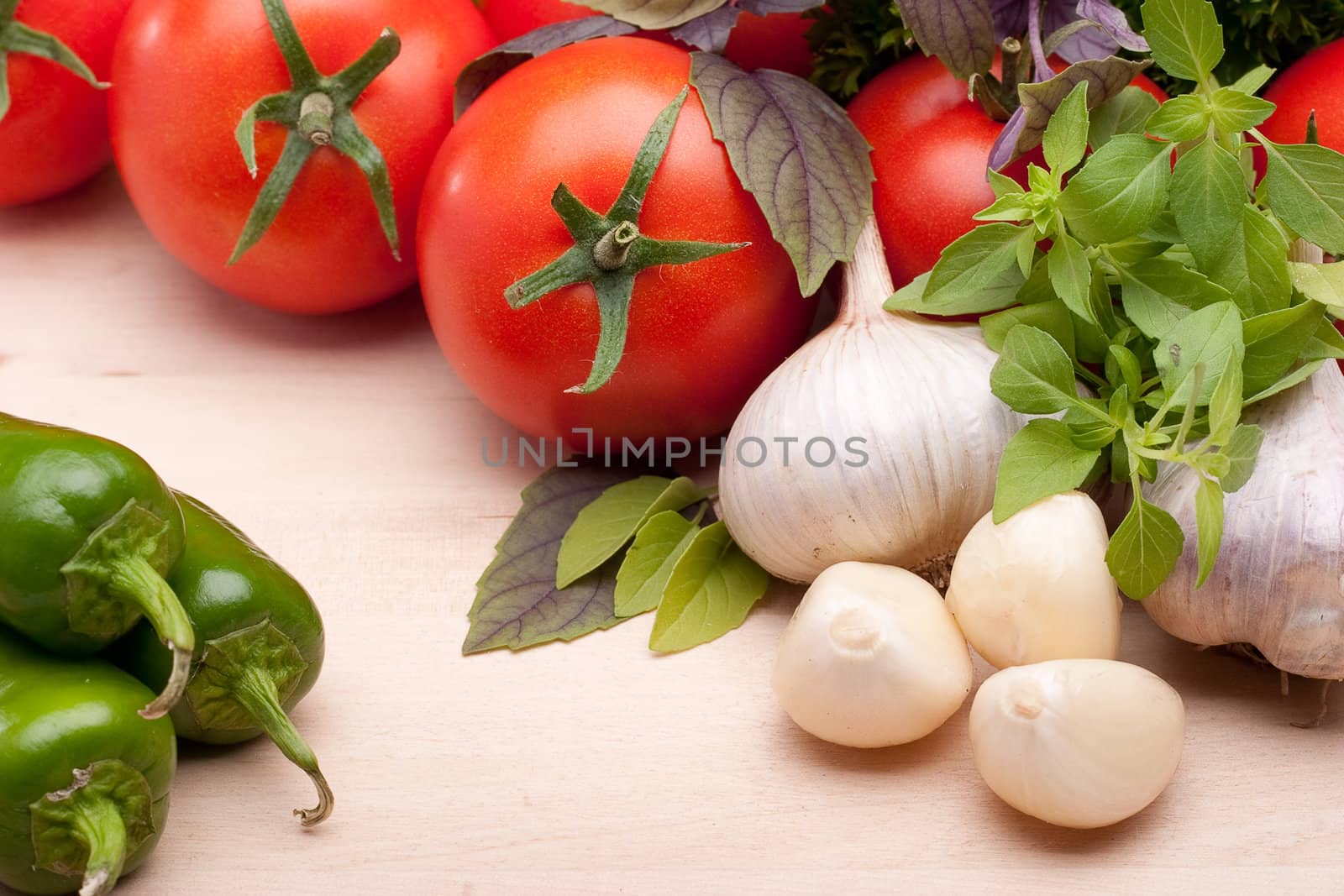 Still life: tomatoes, peppers, garlic and basil on a light background