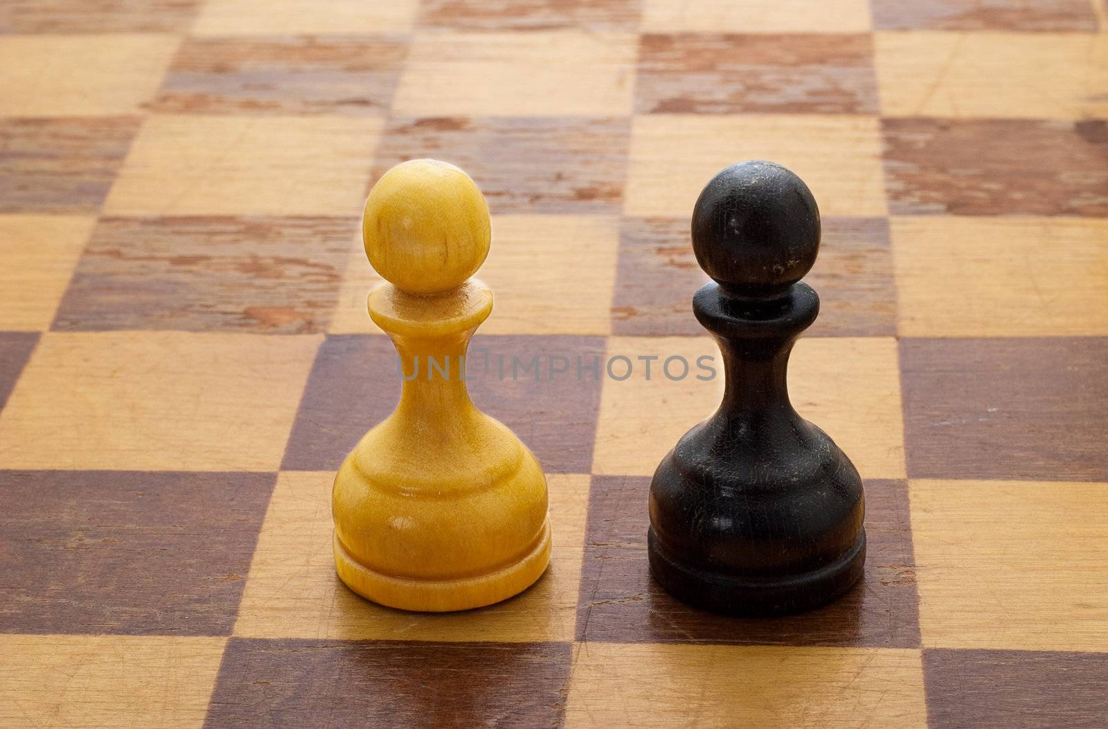Pawns on a chessboard. The concept of battle, playing by the rules