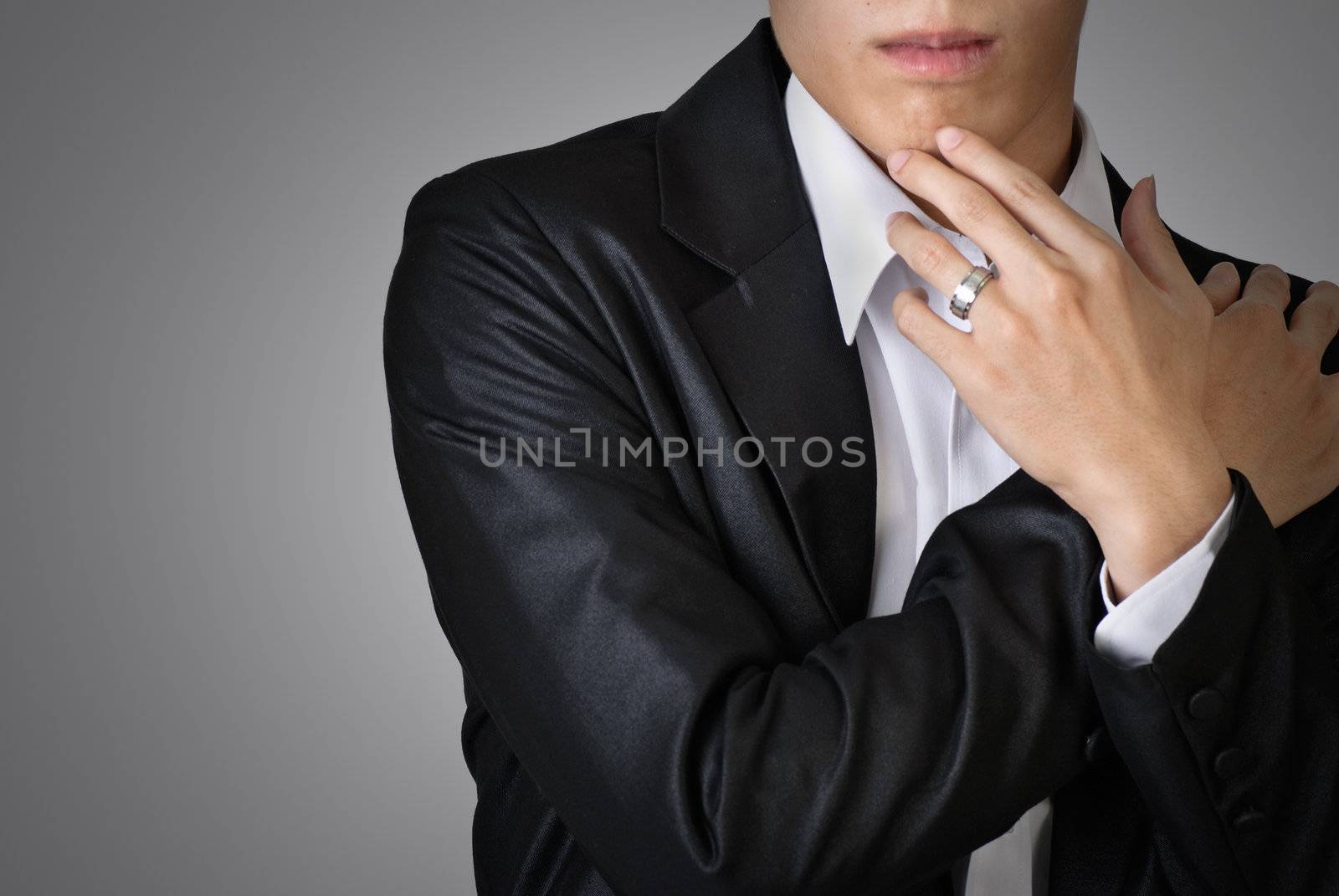 Sexy pose of business man over studio gray background.