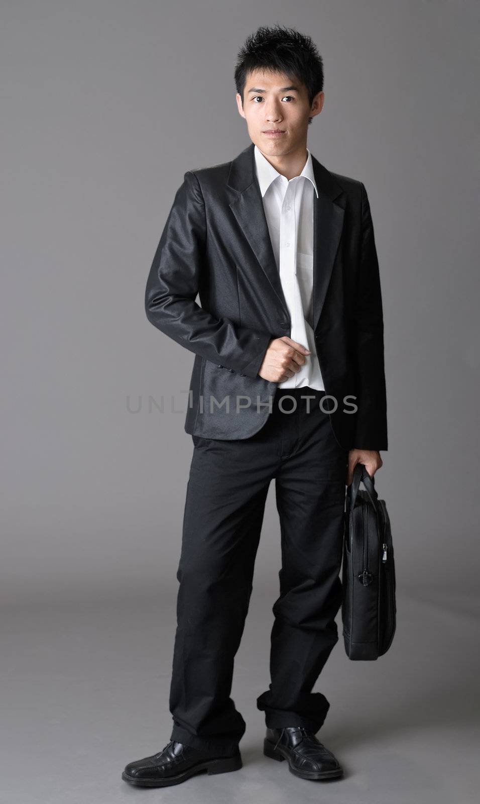 Immature business man of Asian over studio gray background.