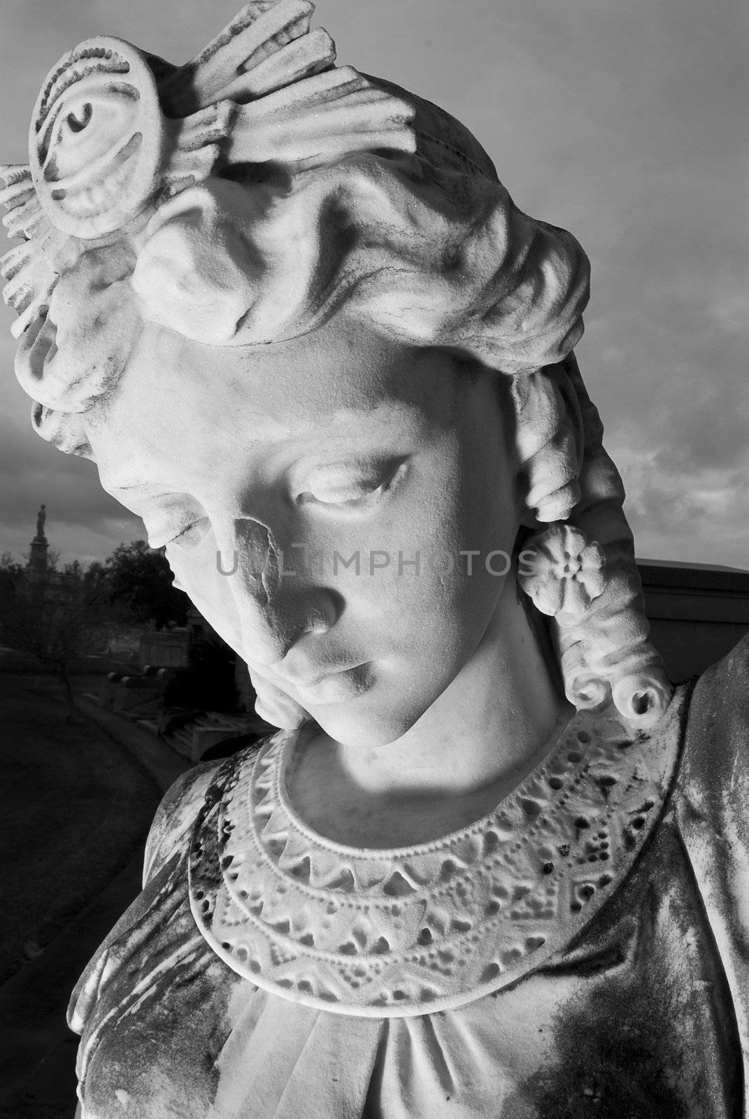 Close up of a mourning statue standing guard outside an egyptian style tomb.