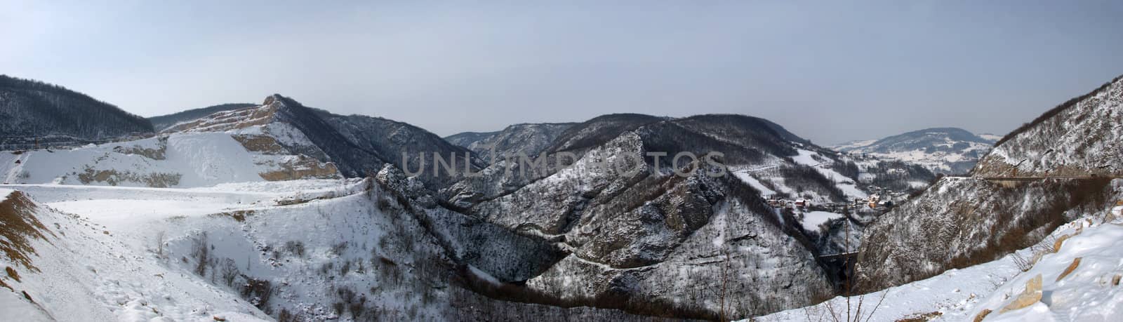 View at snow covered hills with overcast sky.