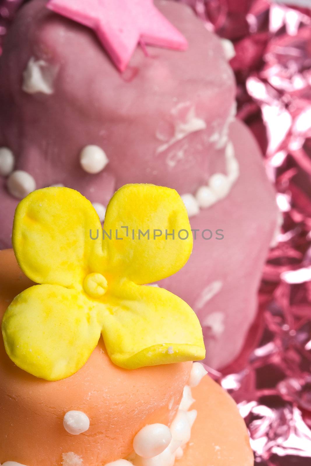 two small nicely decorated cakes yellow and pink 