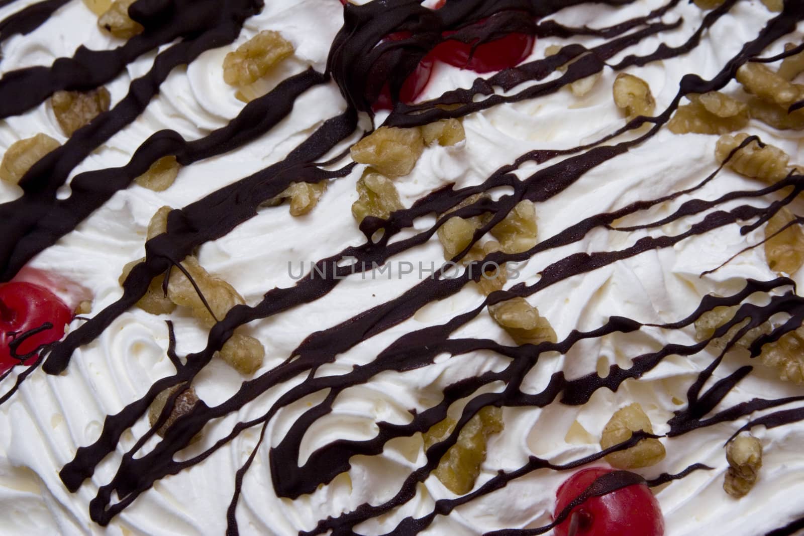 Close up of a bannana cream pie with chocolate drizzled over the top and nuts and cherries