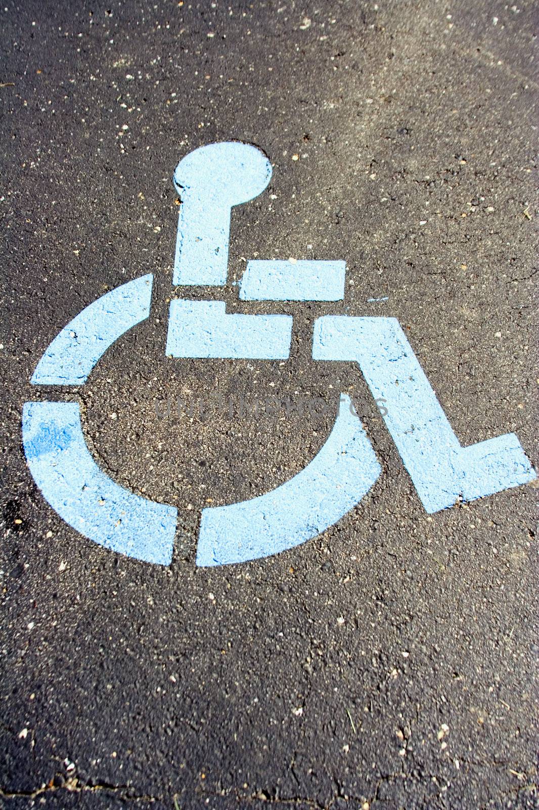 Blue handicap wheel chair marking a reserved parking space