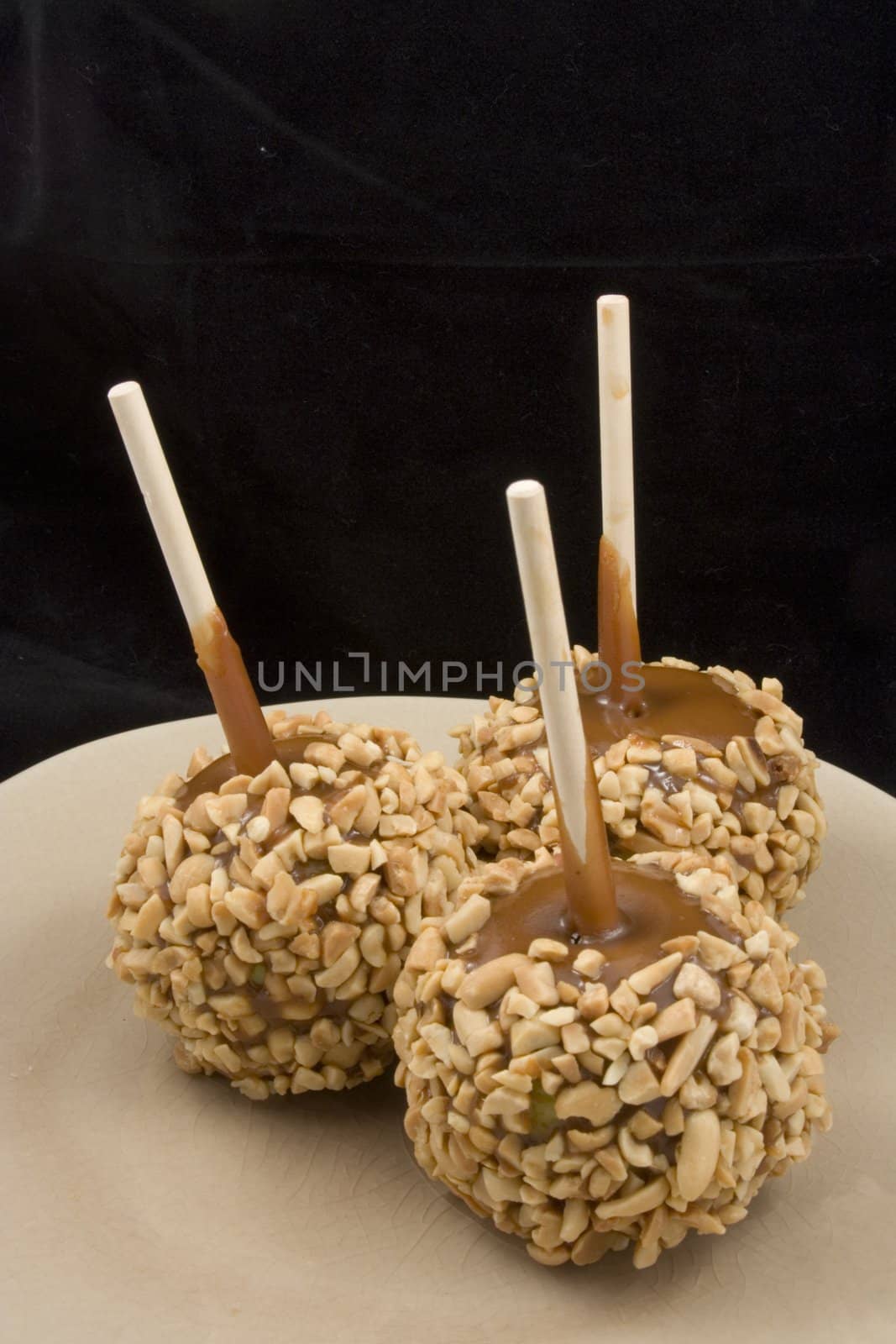 Carmel apples with nuts on a plate just in time for the holidays