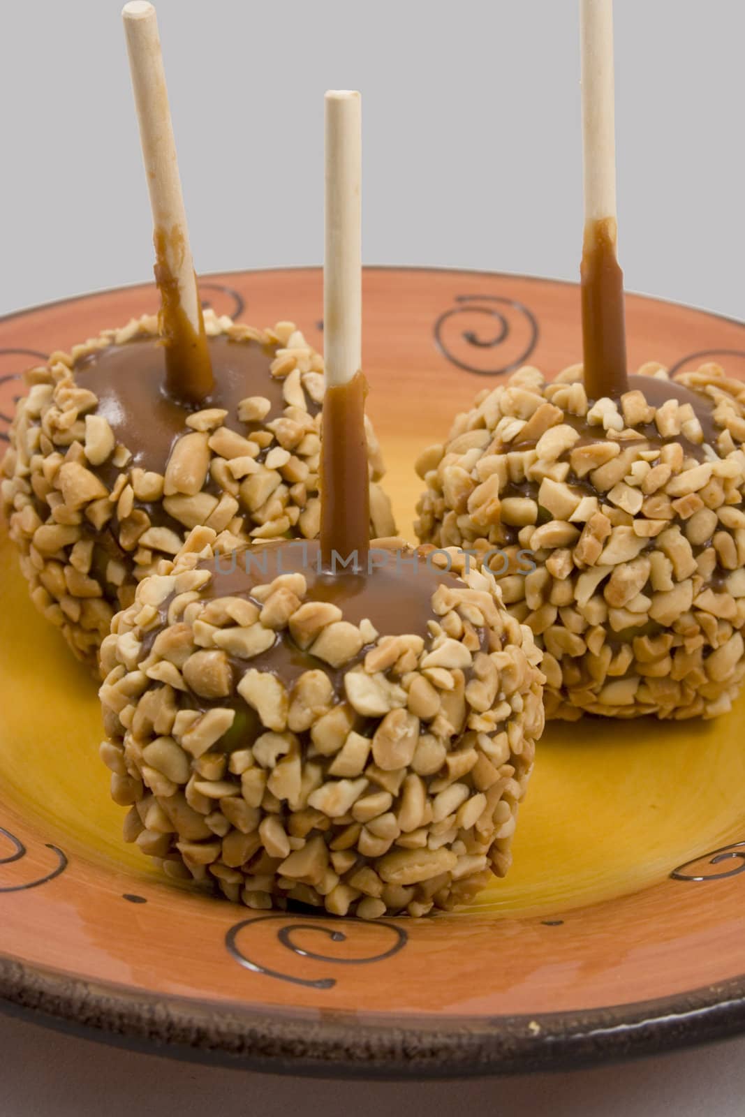 Carmel apples with nuts on a plate just in time for the holidays
