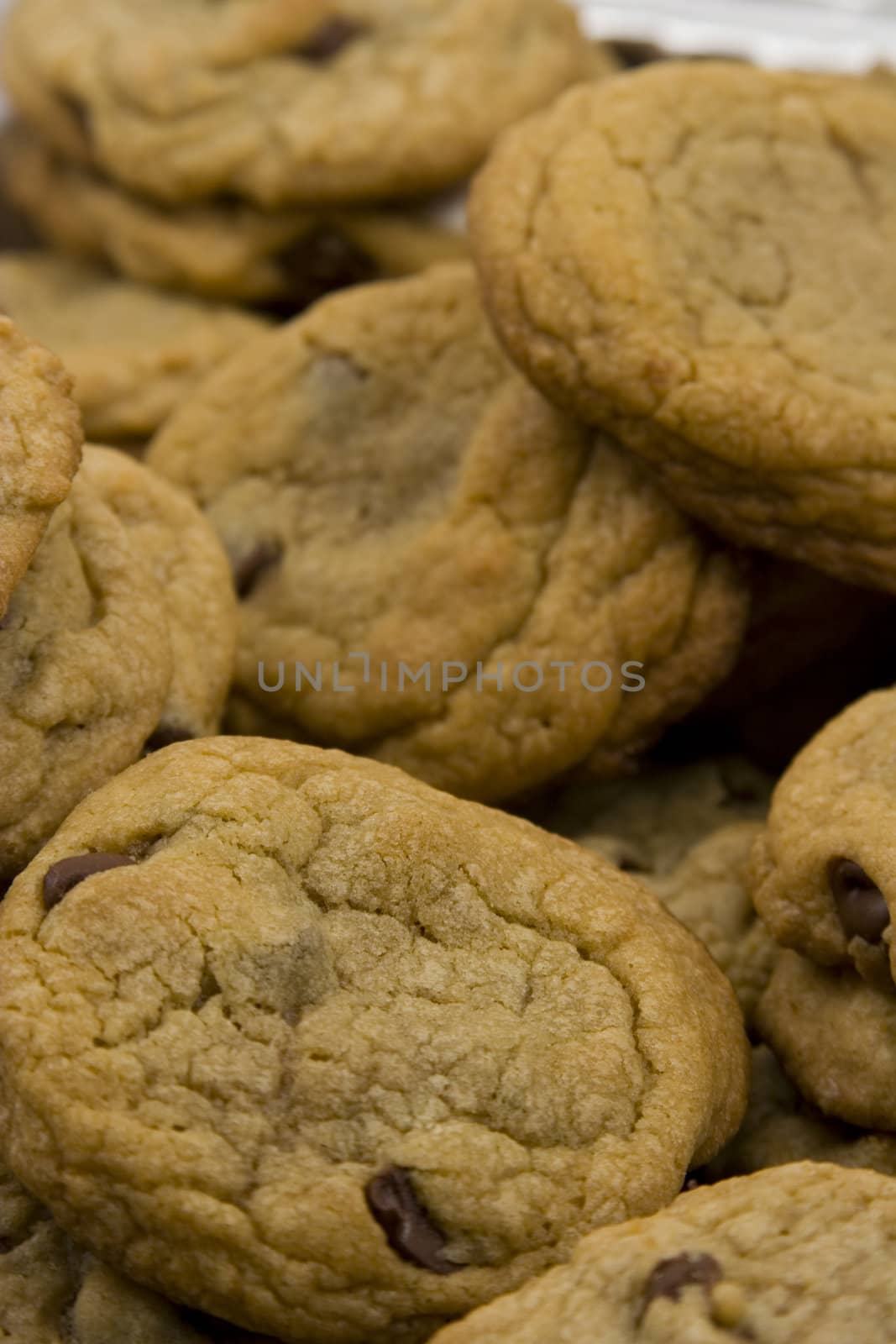 a close up of a mountain of chocolate chip cookies hot to go