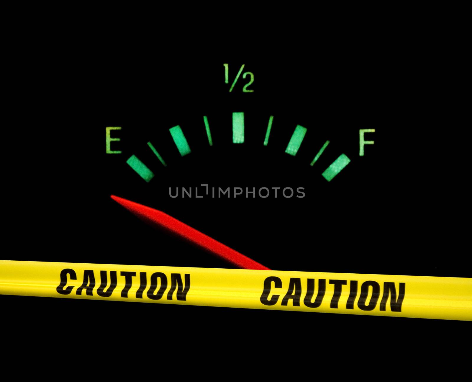 Gas gauge bright colors on empty on a black background with yellow caution tape across the front of it
