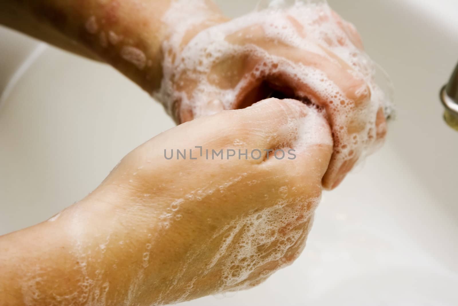 Women washing hands in white sink good suds