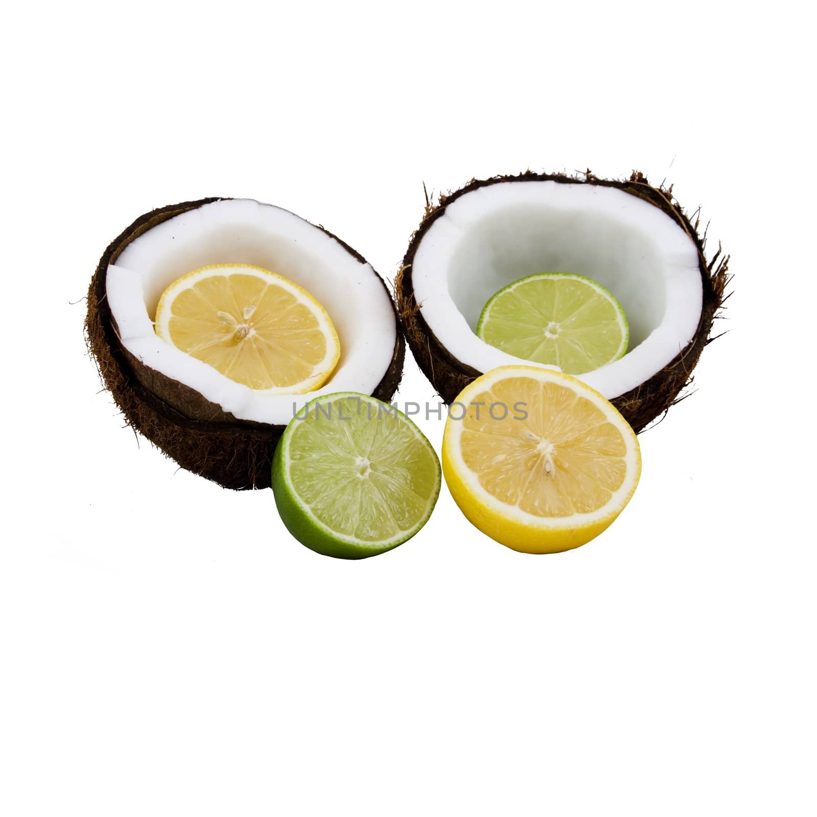 Lemon and lime cut in half placed in front of and inside a coconut that is split open  isolated on a white background