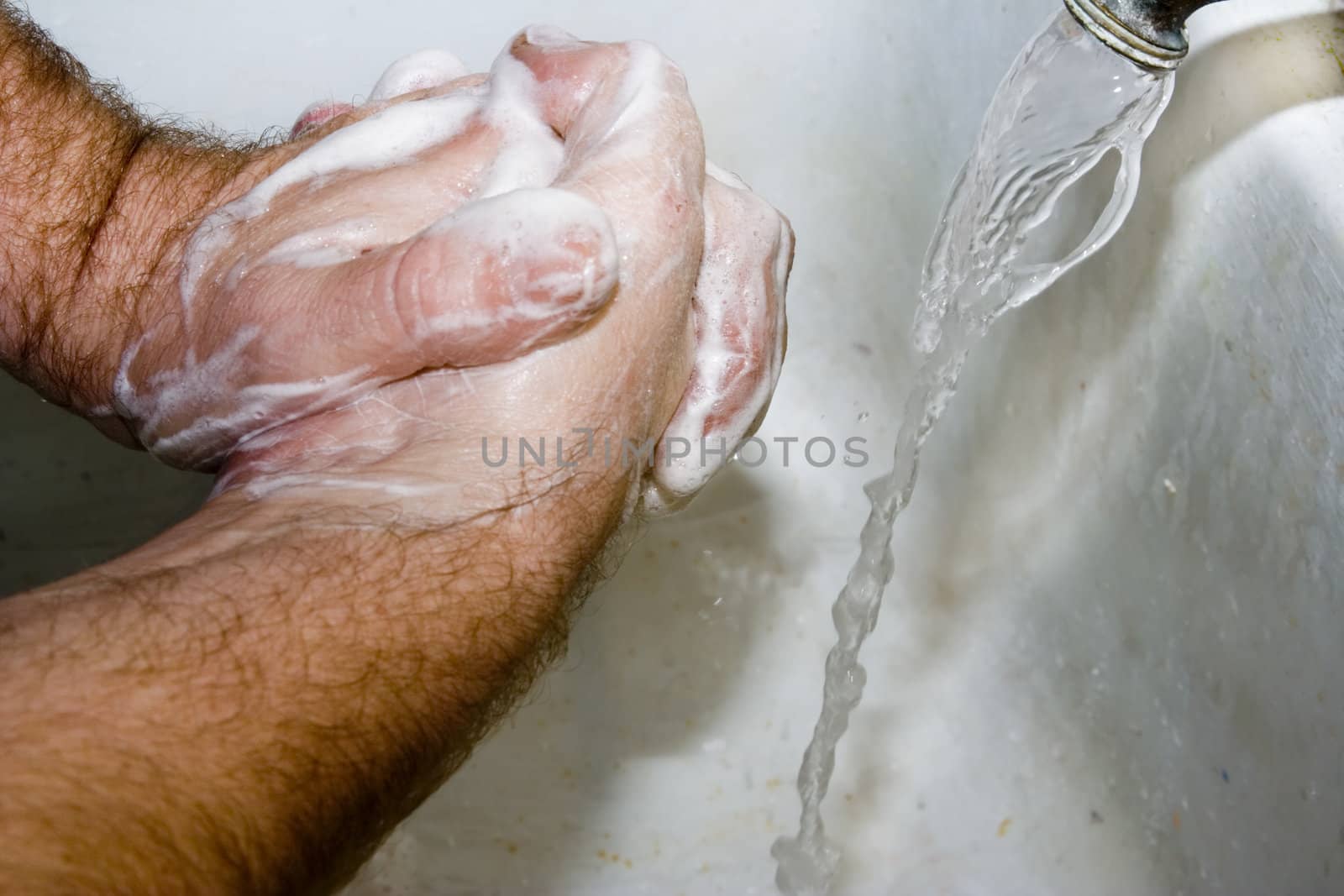 Man washing hands in white sink good suds