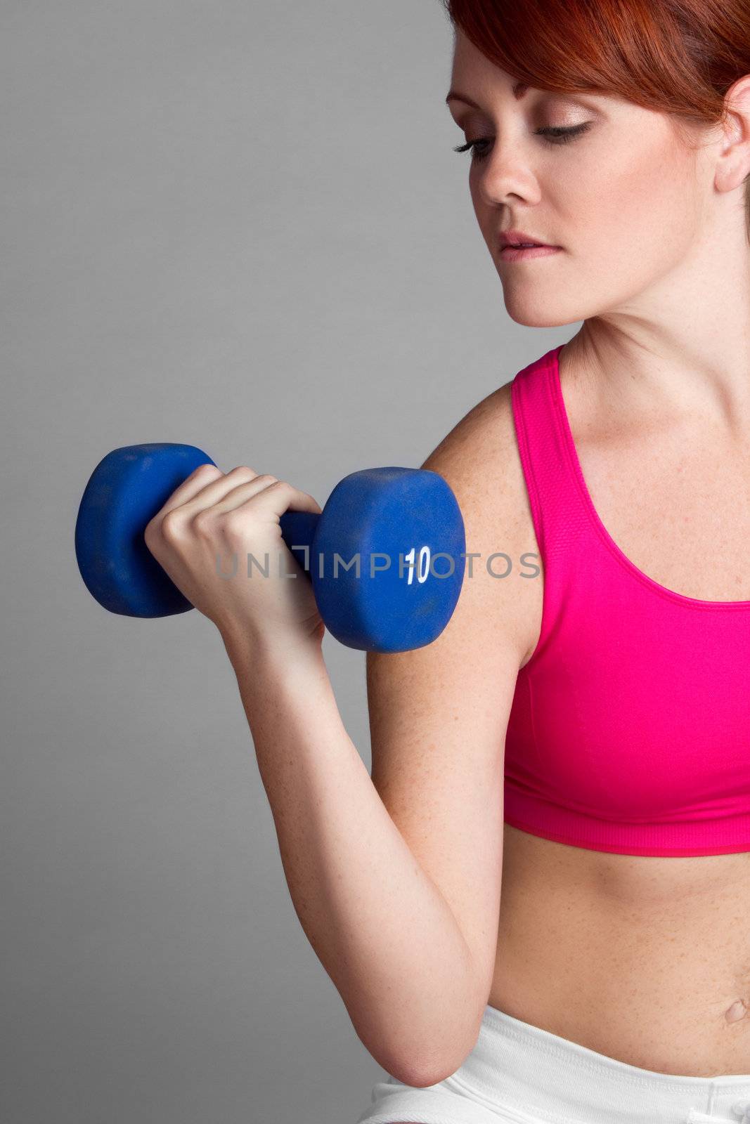 Pretty fitness woman lifting dumbbells