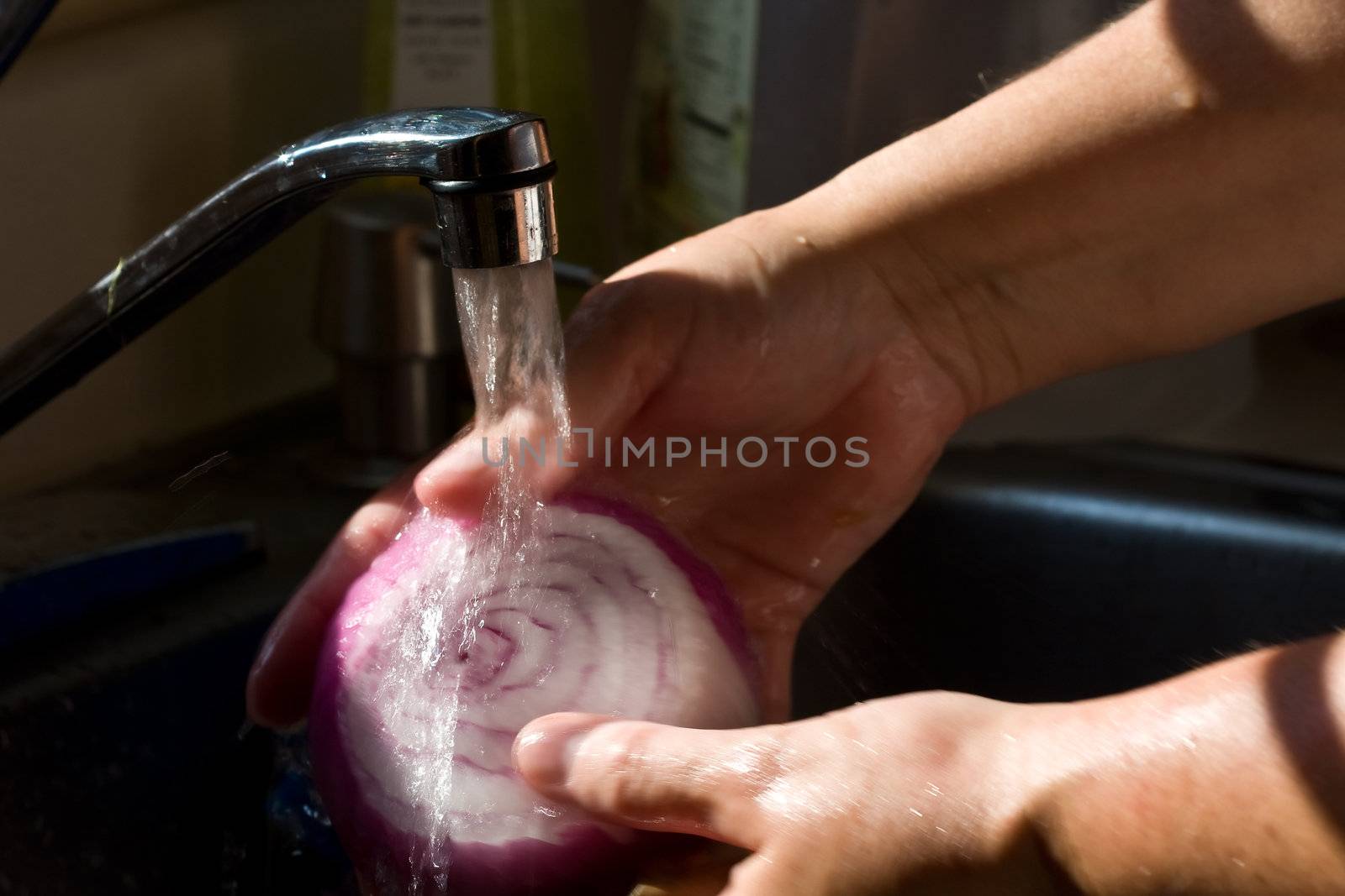 women washing vegetables under running water high contrast