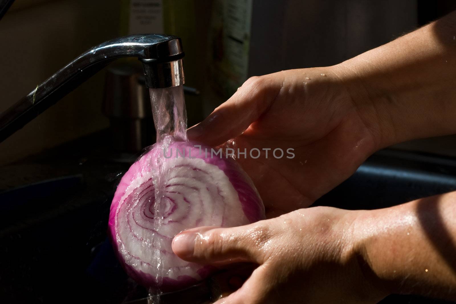 women washing vegetables under running water high contrast