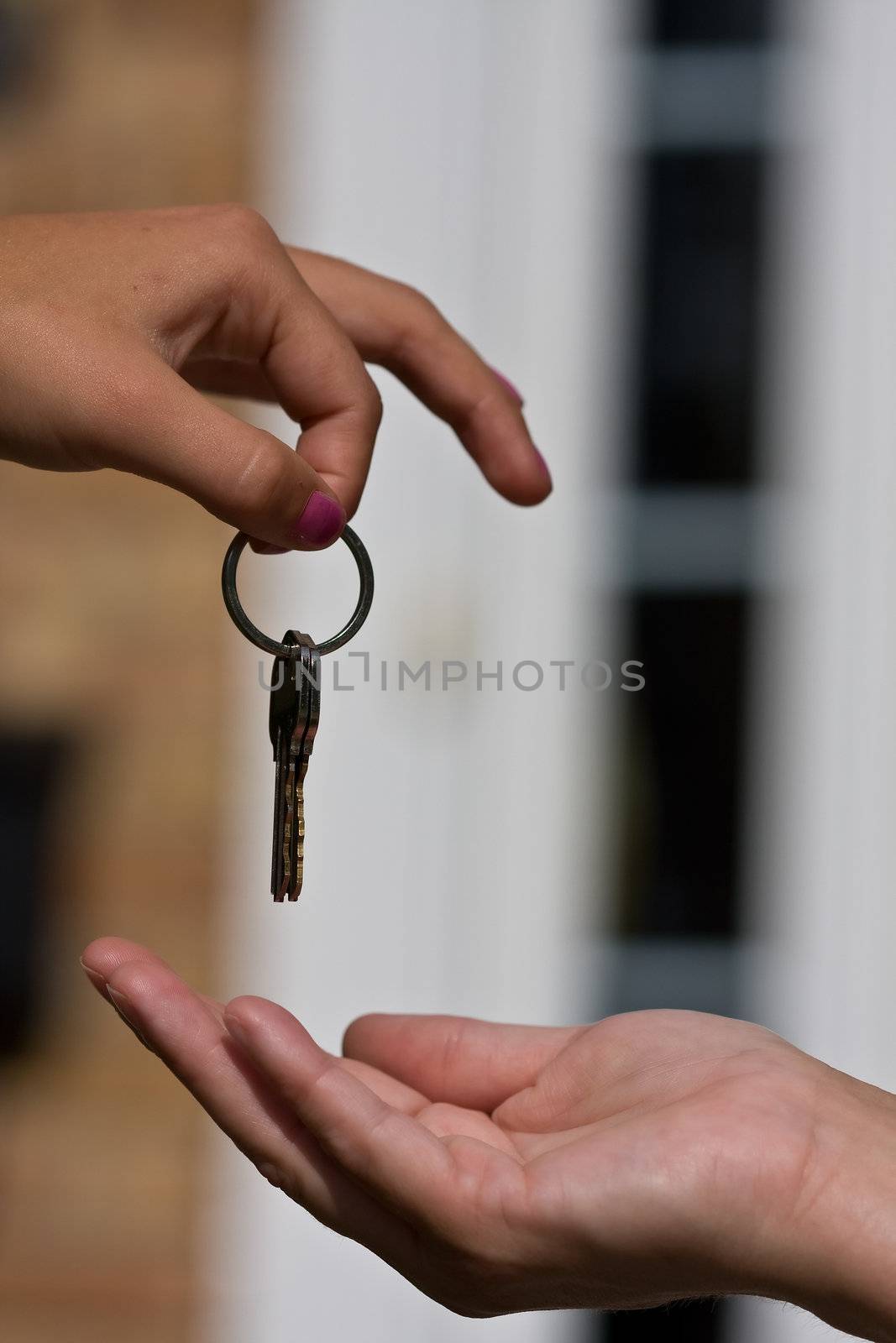 woman handing another woman keys to a house