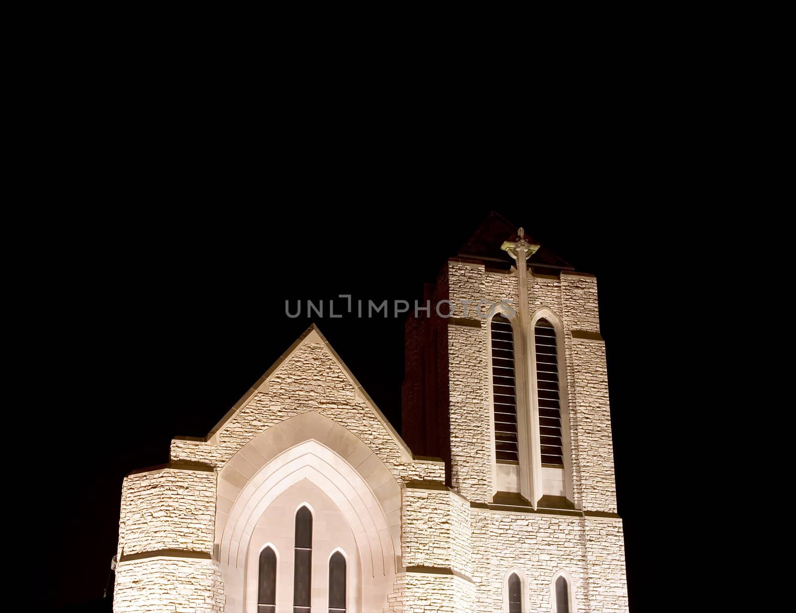 front of a church looking up from below at night white stone